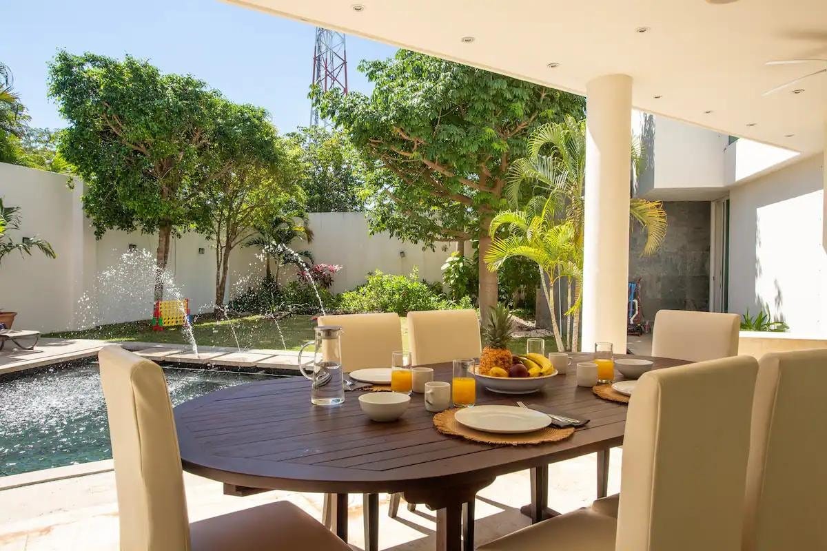 Outdoor dining by the pool at Iboga Wellness Institute Casa Centro in Cozumel