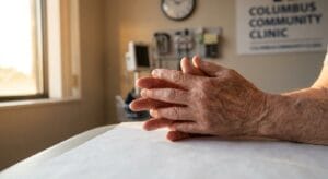 Person's hands resting on medical consultation table in natural morning light, symbolizing the beginning of medically supervised benzodiazepine detox
