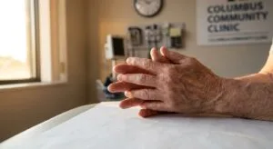 Person's hands resting on medical consultation table in natural morning light, symbolizing the beginning of medically supervised benzodiazepine detox